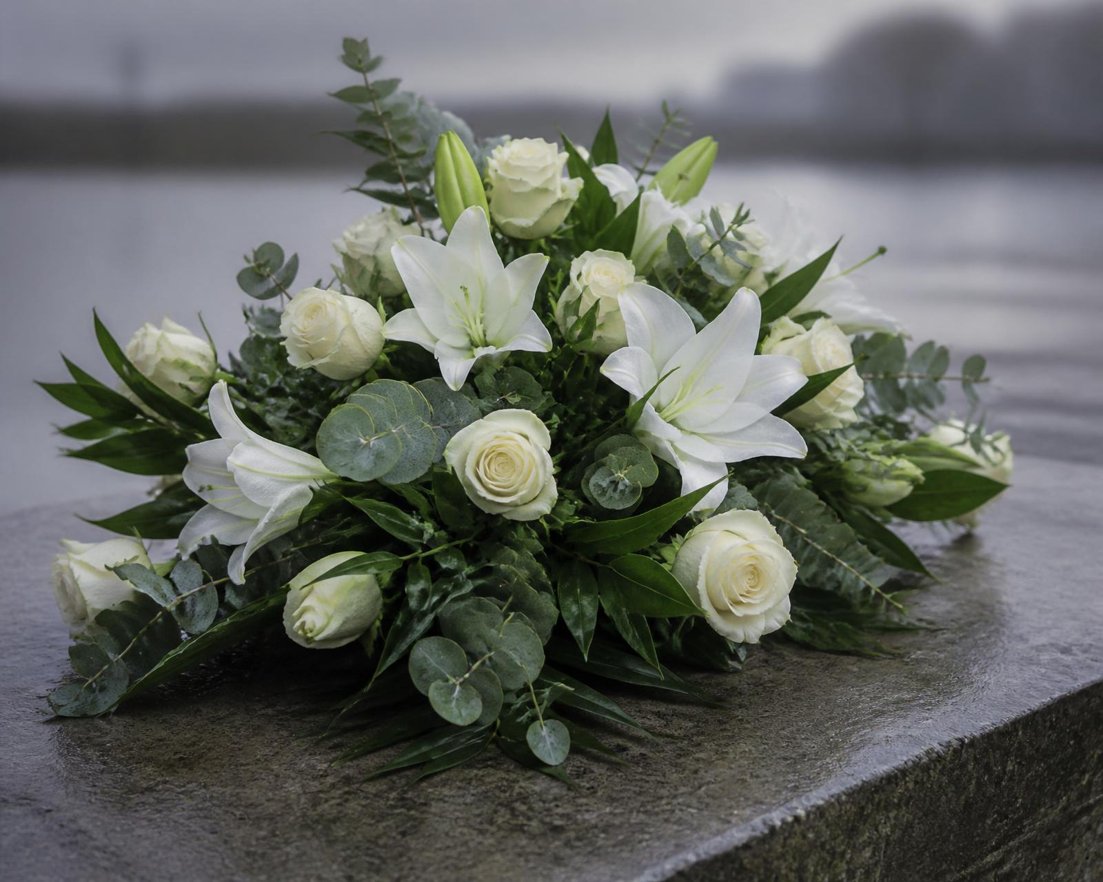 Weißes Trauergesteck aus Lilien und Rosen